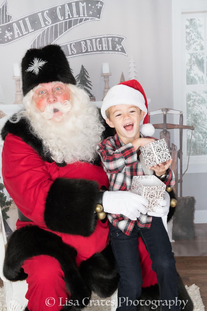 Santa Doug kneeling with two young boys in matching striped pyjamas
